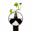 Decorative wall hanging with black tassels and a circular design on a white background
